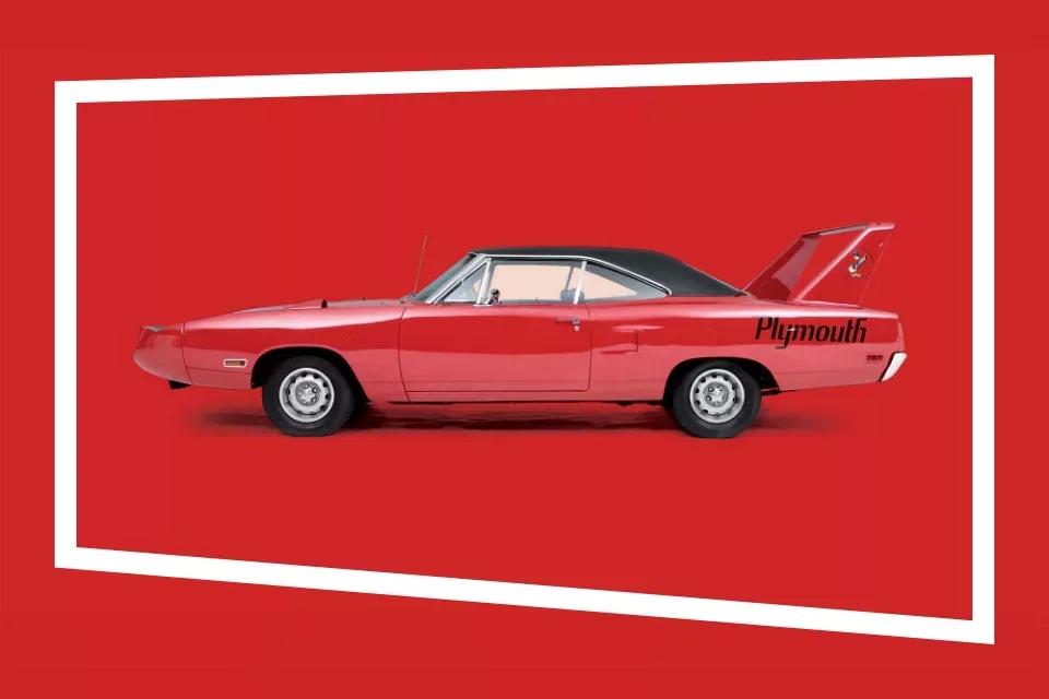 Zijaanzicht van rode cabrio met zwart dak en de tekst 'Plymouth' op de zijkant in een rode studio