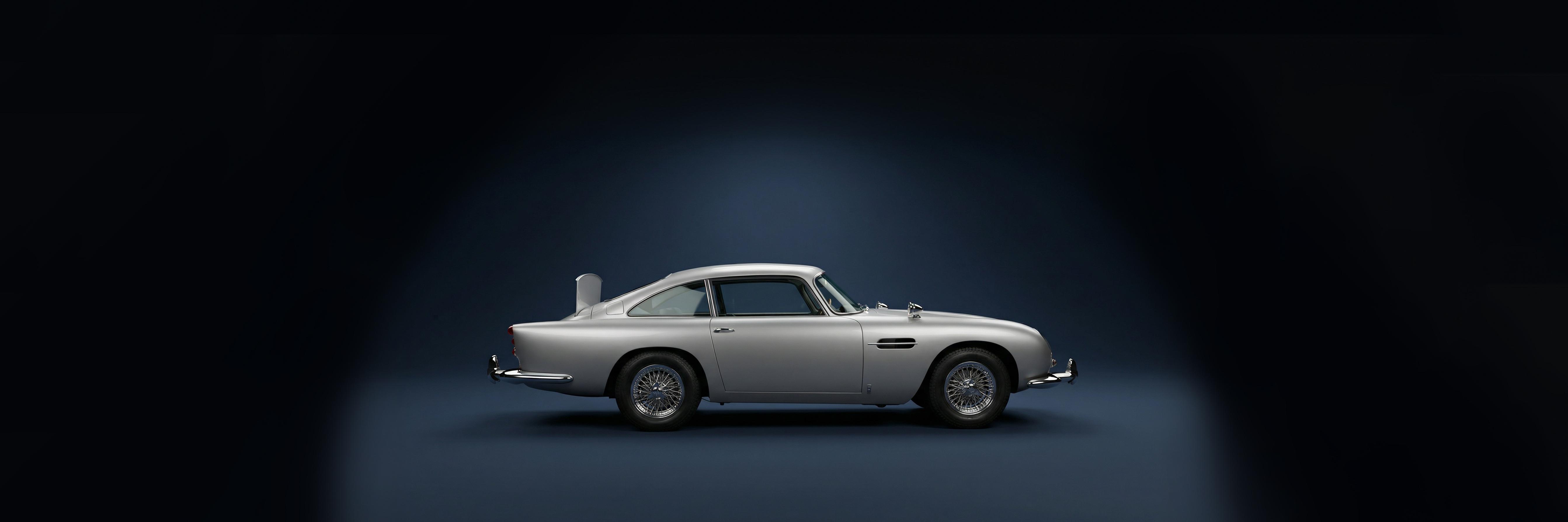 Vue laterale de l Aston Martin dans un studio bleu fonce