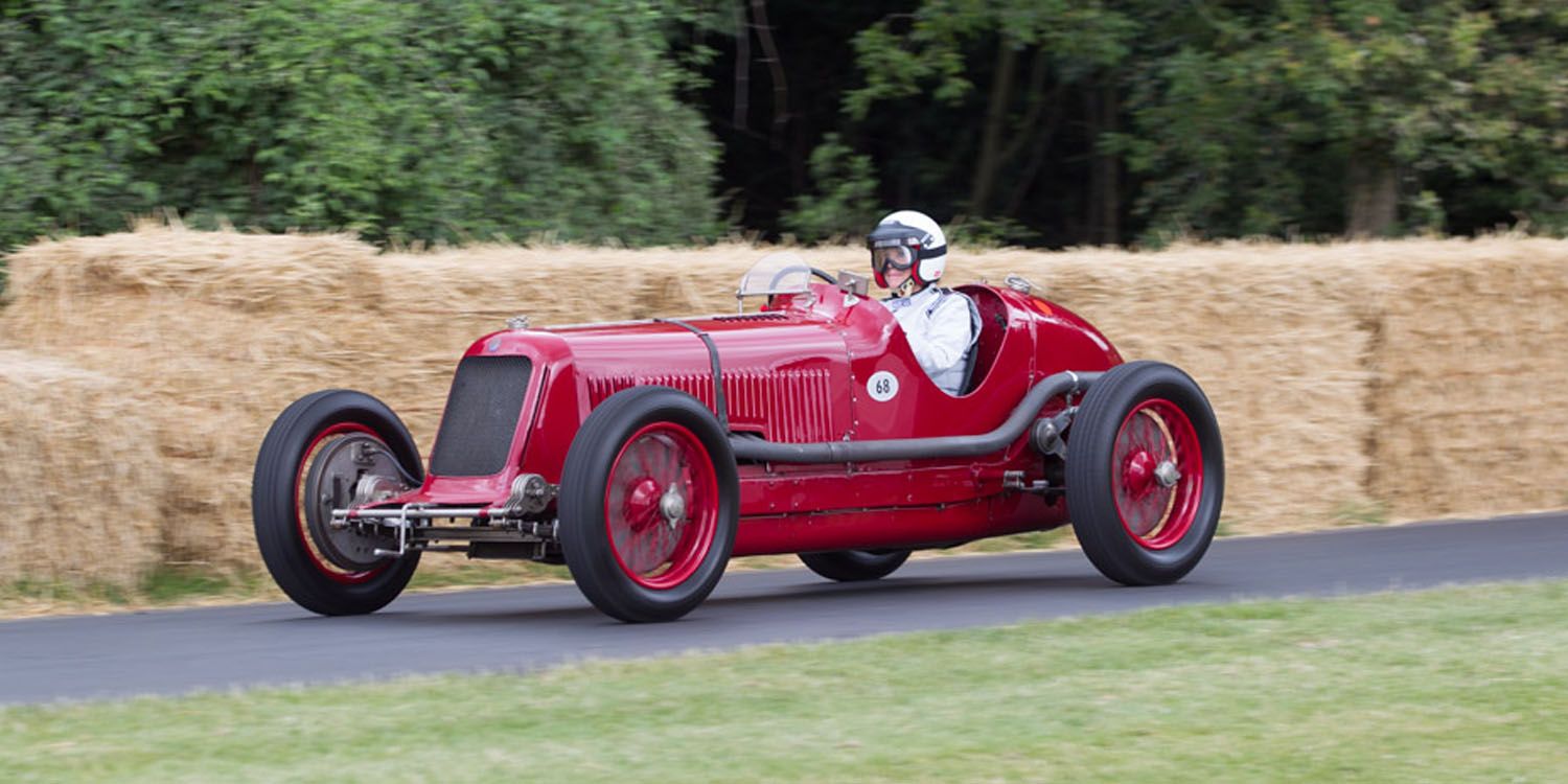 Red Maserati 8CM Monoposto Grand Prix Car past hay bales on the Goodwood circuit