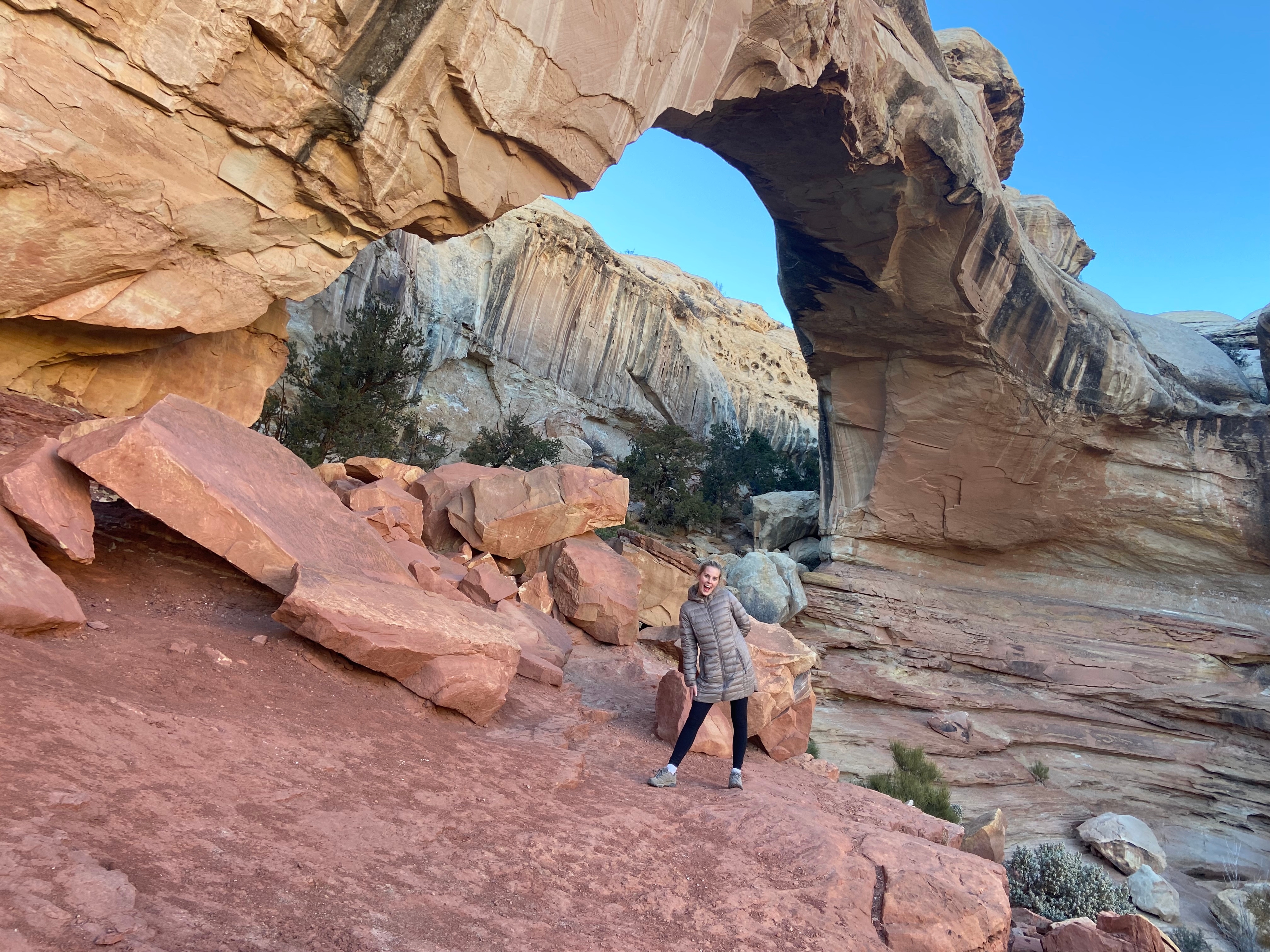 Woman standing underneath Hickman Bridge in Capitol Reef National Park