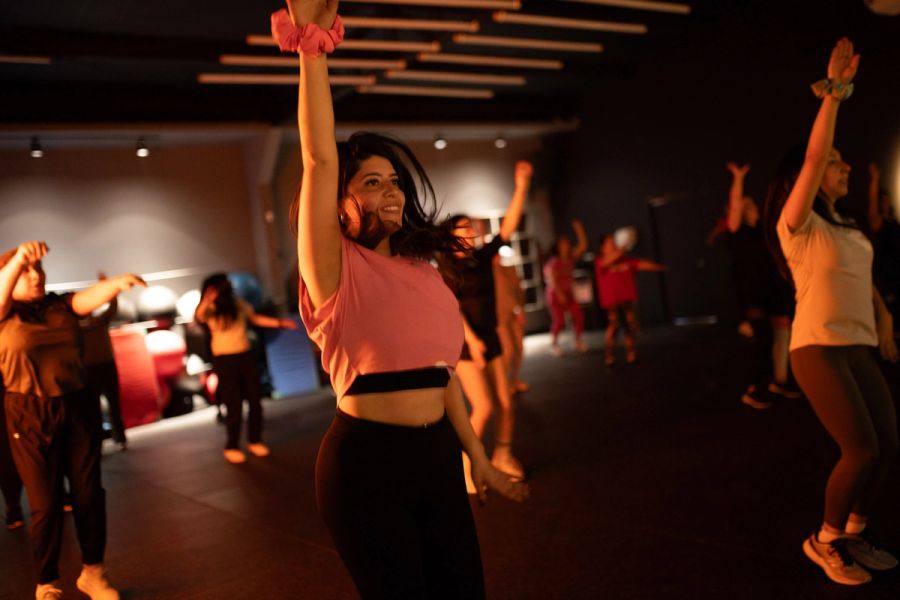 Alumna de Zumba bailando con los brazos arriba