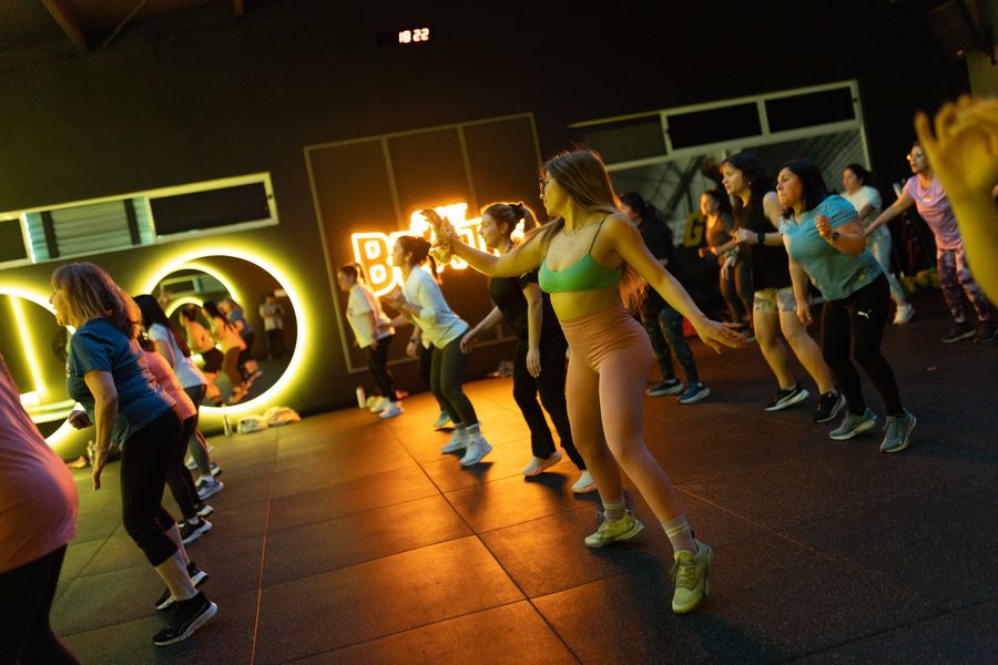 Grupo bailando Zumba frente a los aros de luz de la sala Beats