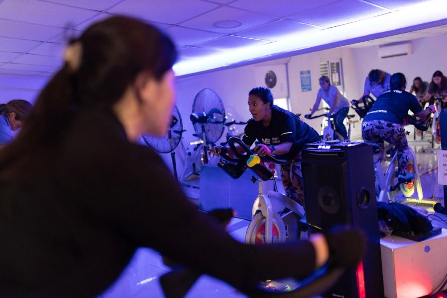 Profesora de ciclismo indoor guiando la clase desde su bicicleta