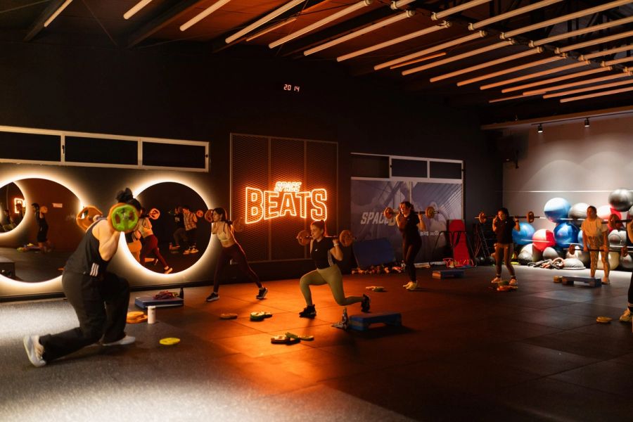 Clase de Body Pump con barras y discos bajo las luces de la sala Beats de Nutre y Entrena