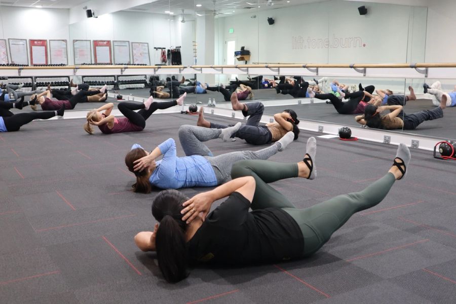 Clase grupal haciendo abdominales en el piso