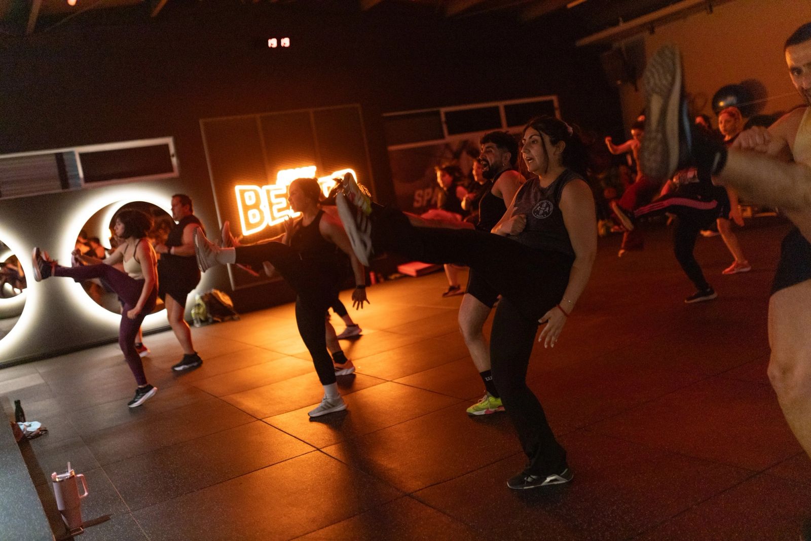 Alumnas de Body Combat lanzando una patada frontal frente al letrero BEATS