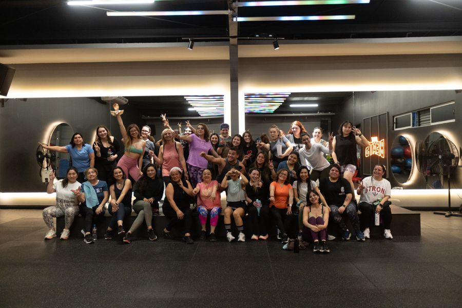 Foto grupal de socias y socios después de la clase de Zumba en la sala Beats de Nutre y Entrena