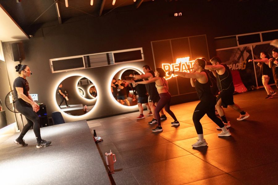 Profesora de Body Combat guiando al grupo desde el escenario