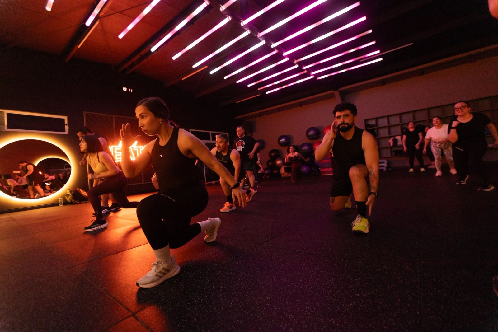Grupo de Body Combat en zancada con la rodilla cerca del piso