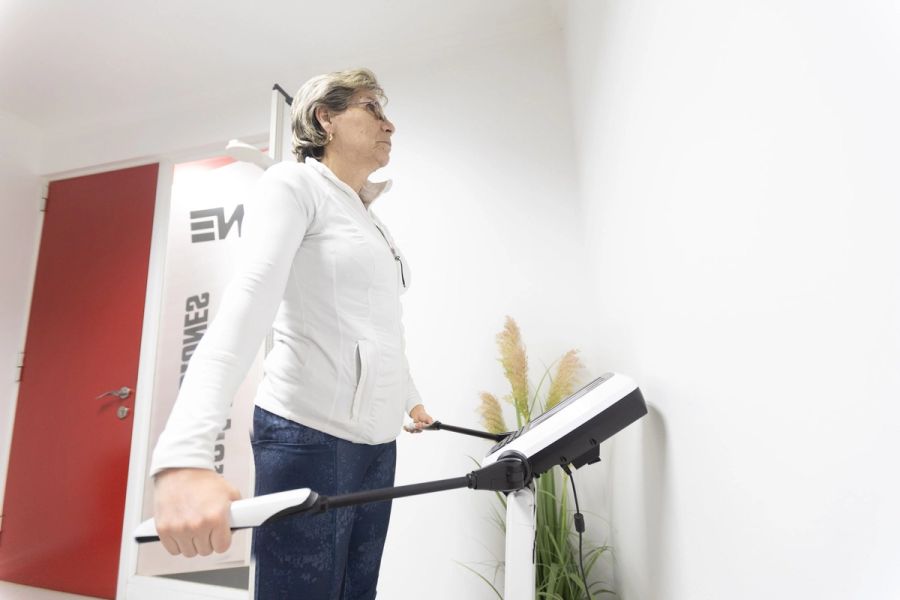 Socia de pie en el InBody 270 sosteniendo los electrodos durante su evaluación de composición corporal