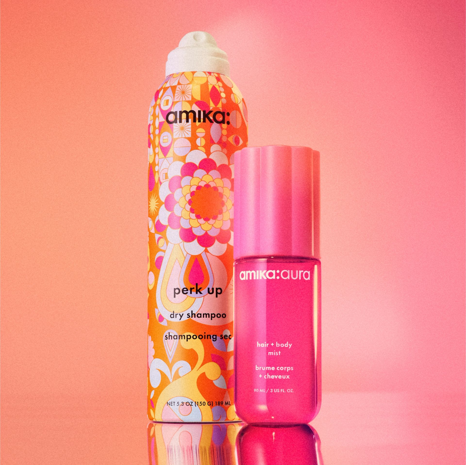 image of amika aura and perk up dry shampoo against a pink and orange background.