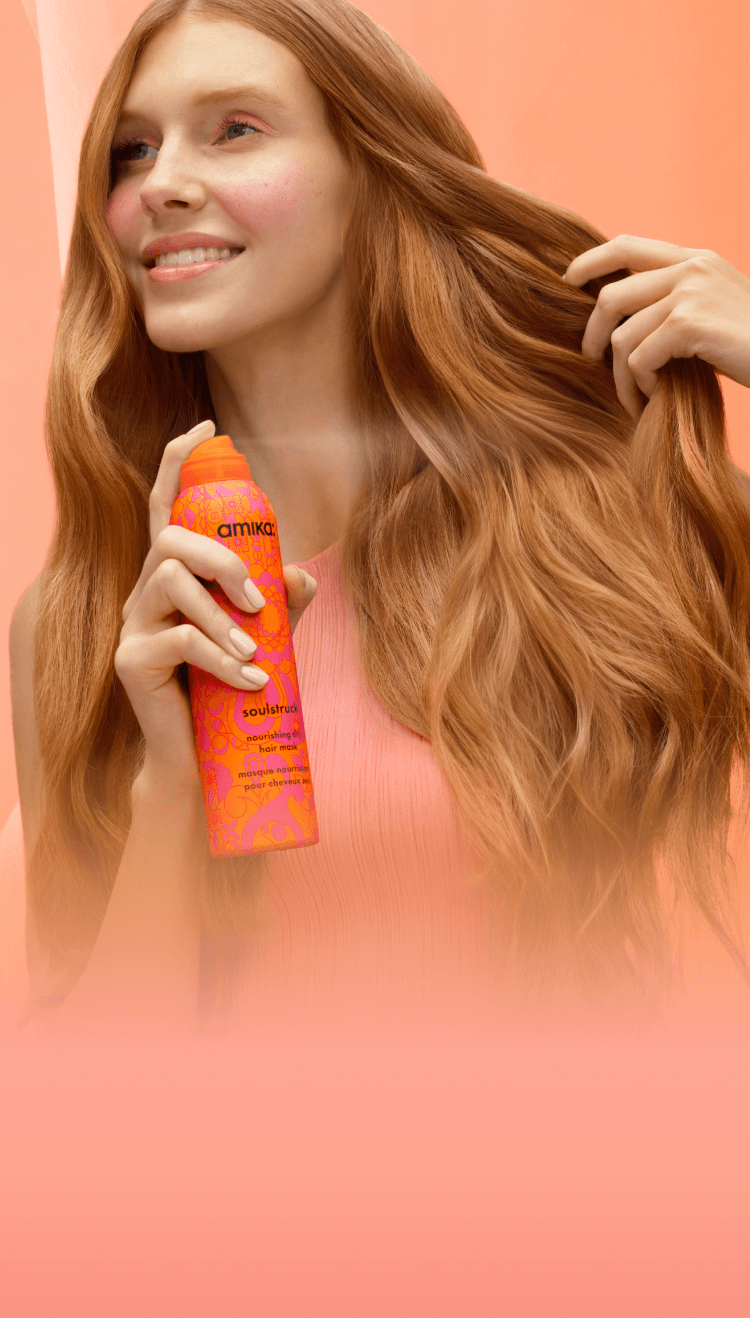 soulstruck model spraying product in front of a pinkish-orange background