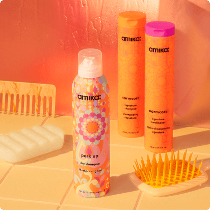 image of amika signature collection hero products: normcore shampoo + conditioner bottles and perk up dry shampoo
