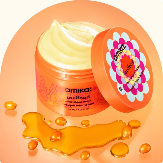 image of a container of amika soulfood nourishing mask with the lid next to the container so that the product mask is exposed. In front of the container are some sea buckthorn berries, this product's hero ingredient.