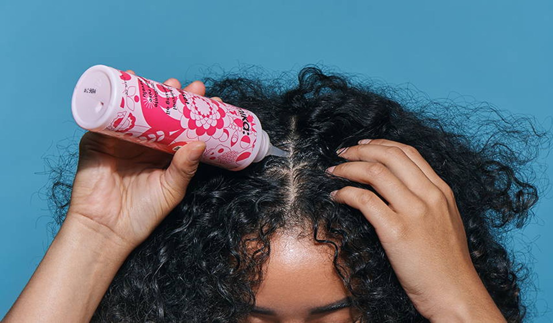 person applying reset pink charcoal scalp cleansing oil