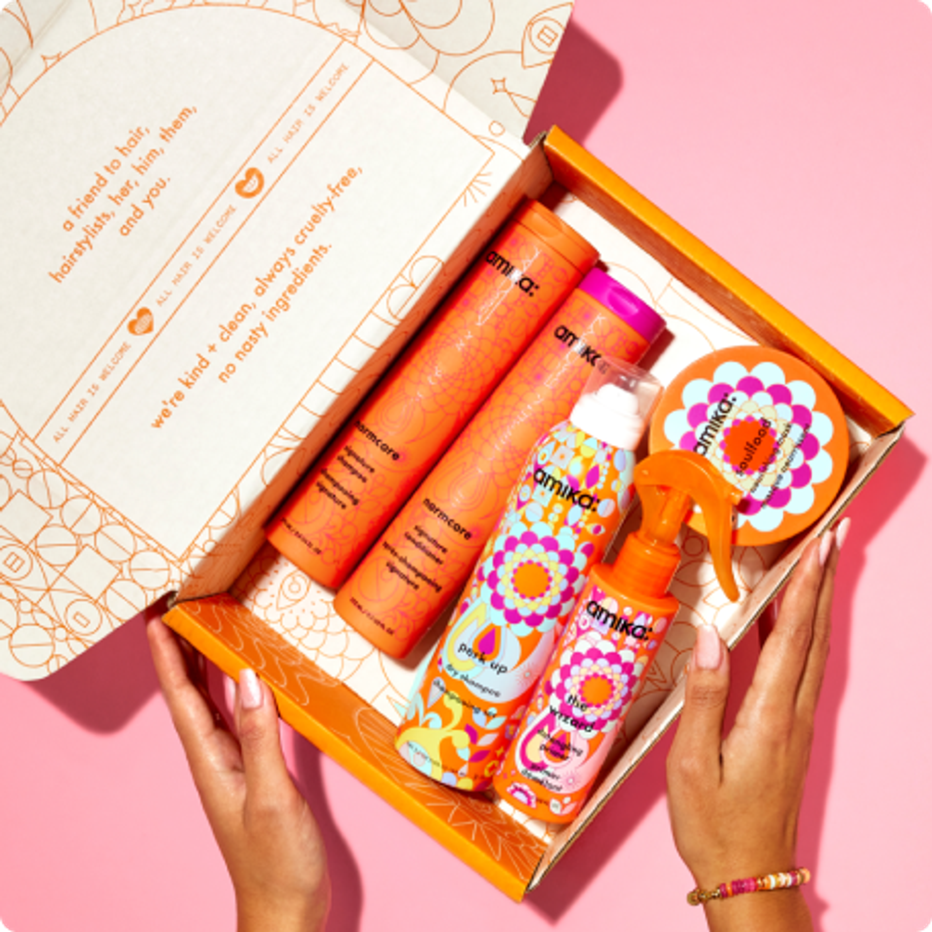 an amika mailer box with signature amika products including normcore shampoo and conditioner, perk up dry shampoo and wizard detangling primer and soulfood nourishing mask
