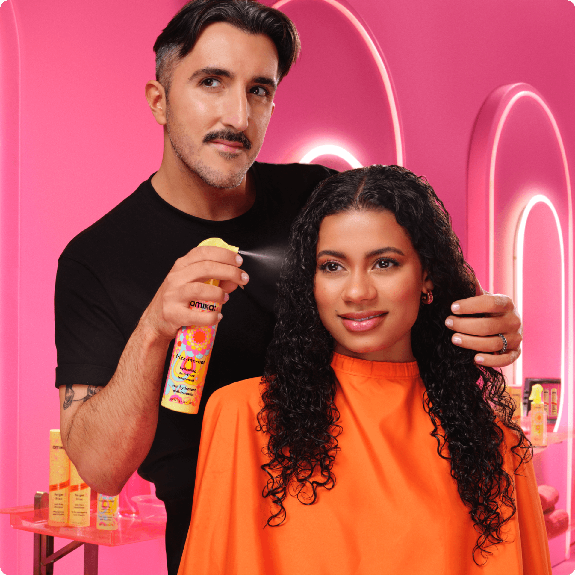 Image of stylist using the NEW frizz-me-not treatment on a curly-haired model.