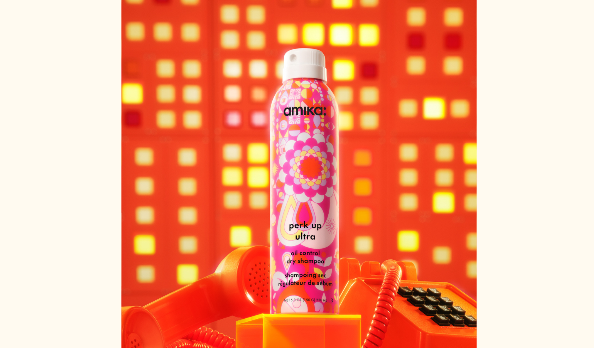 amika perk up ultra oil control dry shampoo spray bottle 5.3oz - pictured with an orange telephone against a geometric background