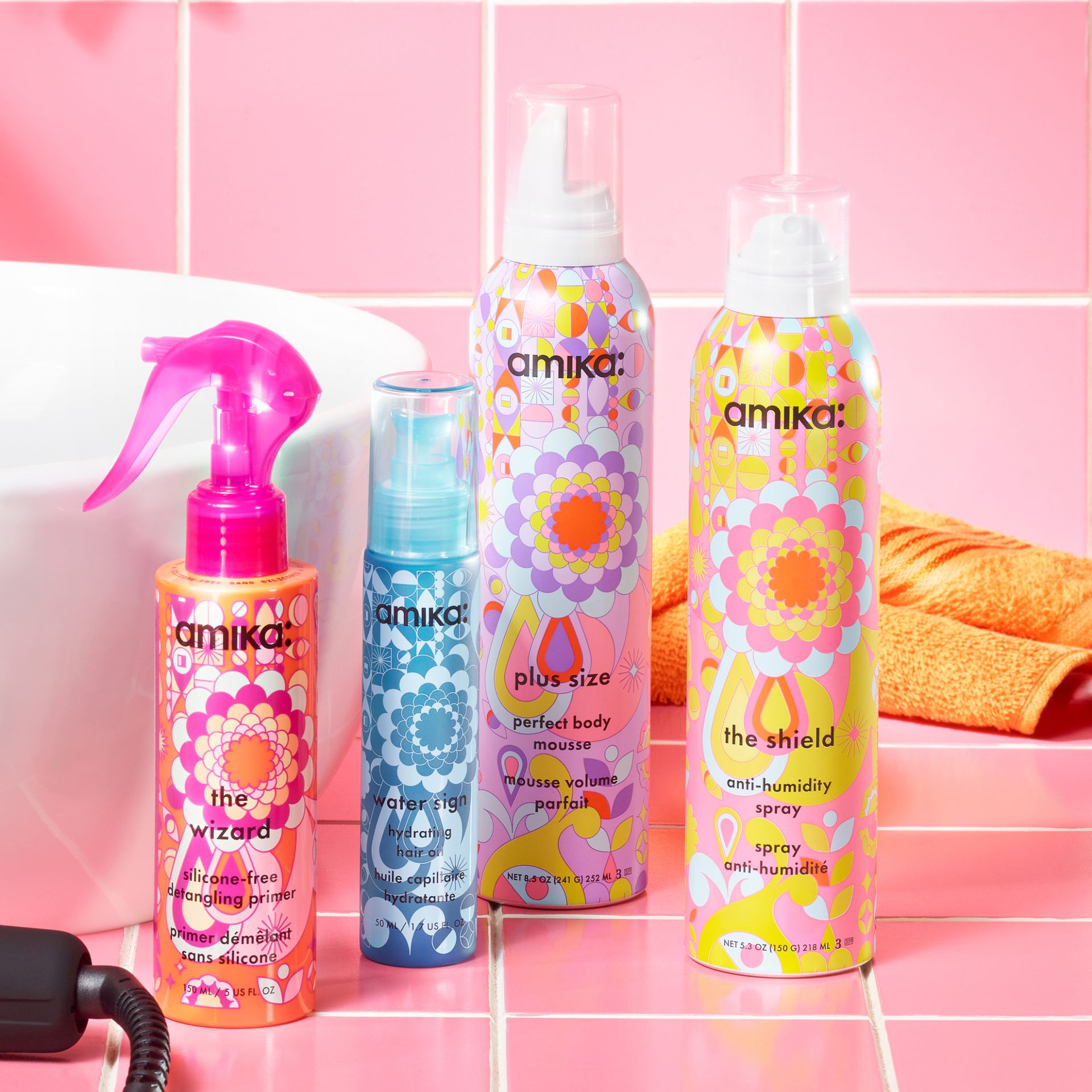 amika products with heat protection: the wizard silicone-free detangling primer, water sign hydrating oil, plus size perfect body mousse, and the shield anti-humidity spray