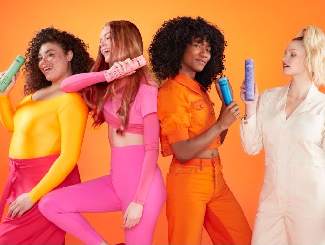 group of models holding different amika shampoo bottles