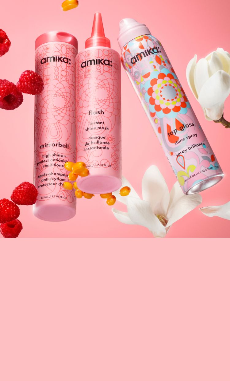 amika mirrorball conditioner, flash instant shine mask and top gloss shine spray on a pink background surrounded by raspberries and white flowers