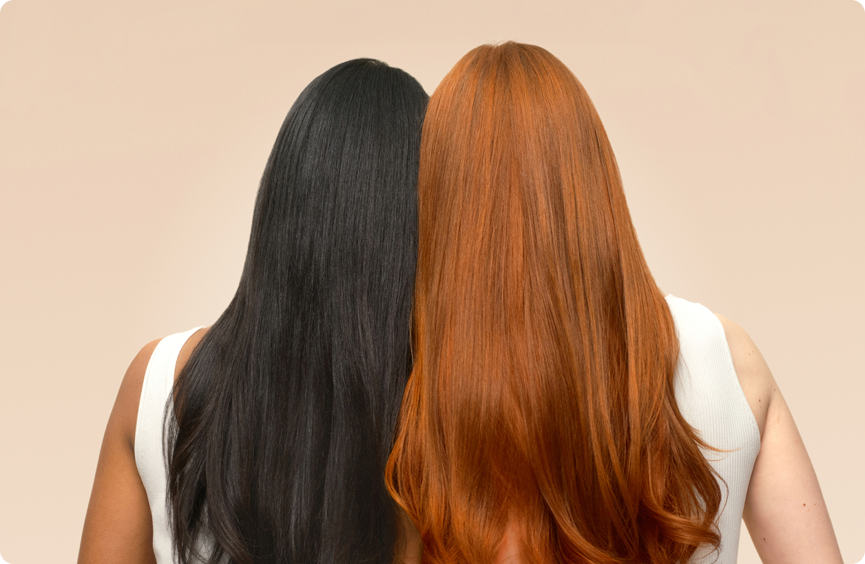 two models with long hair facing backward against a cream background