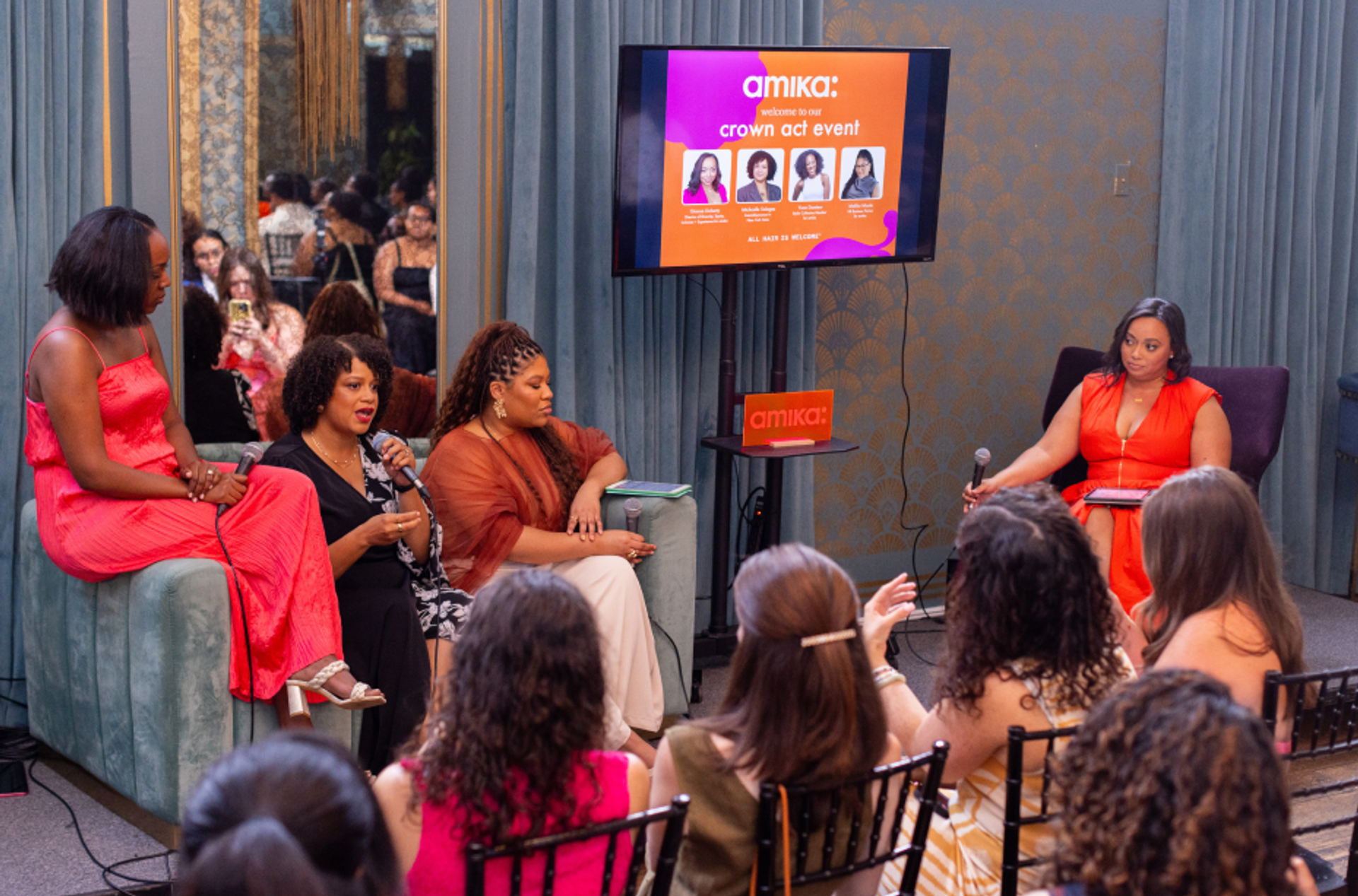 a panel of ladies speaks in from of an audience at the Crown Act Event