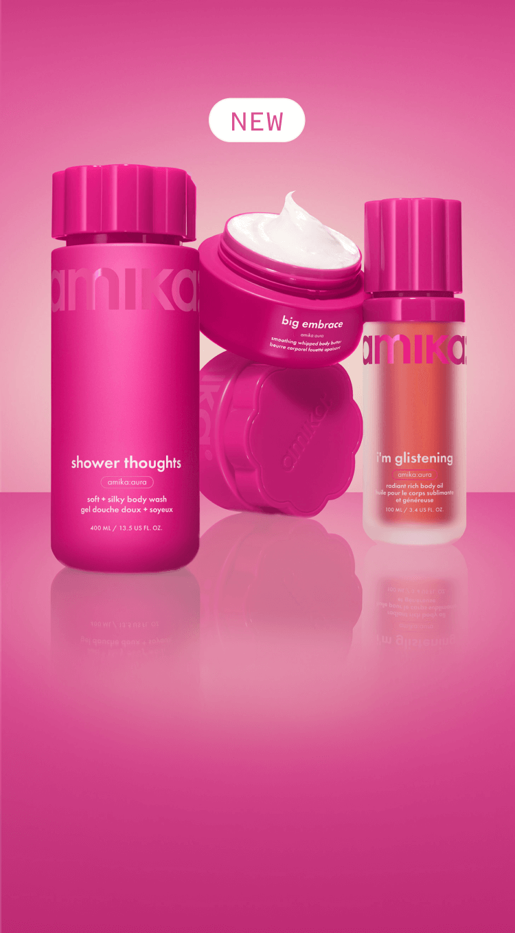 amika shower thoughts body wash, i'm glistening body oil, and big embrace body butter sit against a pink gradient background