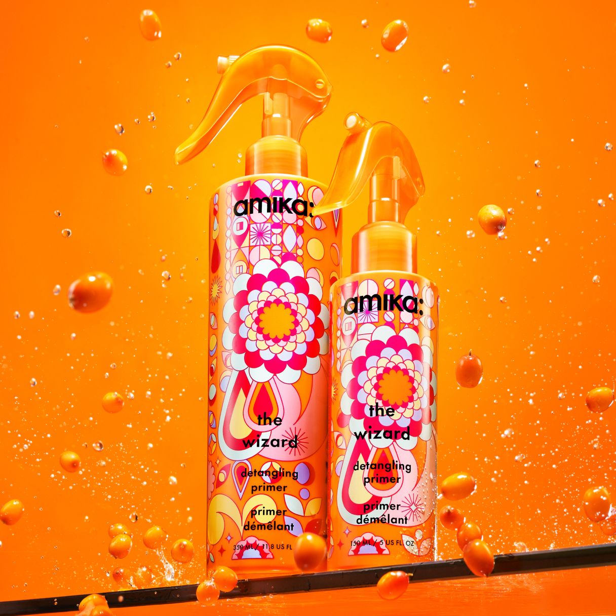 two bottles of the wizard detangling primer on a shelf with an orange background and seabuckthorn surrounding the bottles