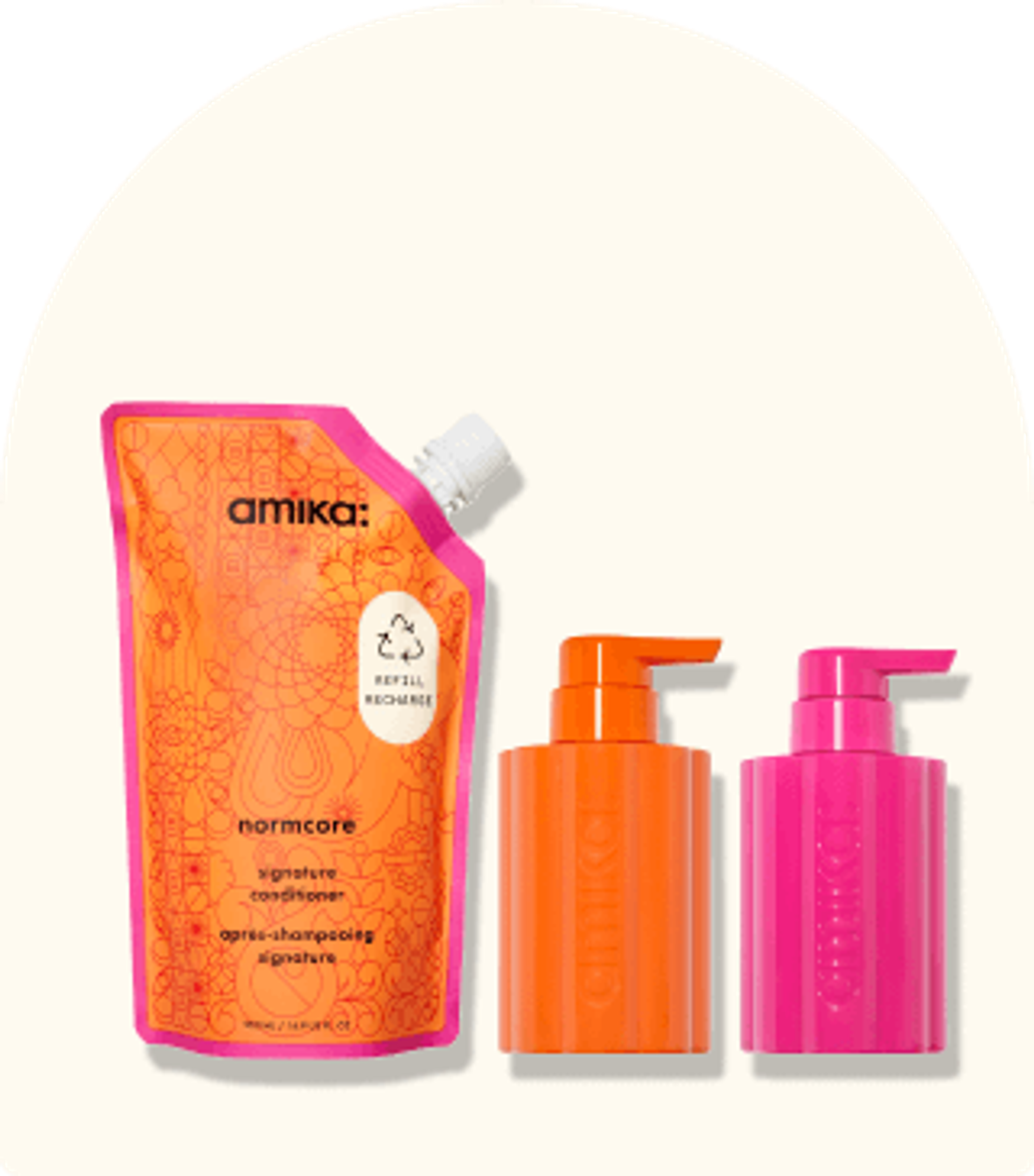 image of amika refill bundle, normcore refill pouch and one pink and one orange refillable bottles sit against a cream background.