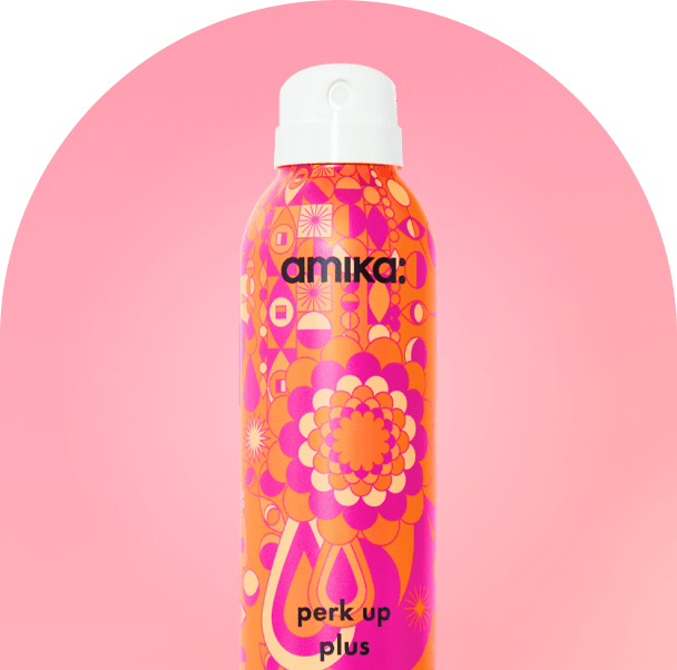 amika perk up plus bottle against a pink background