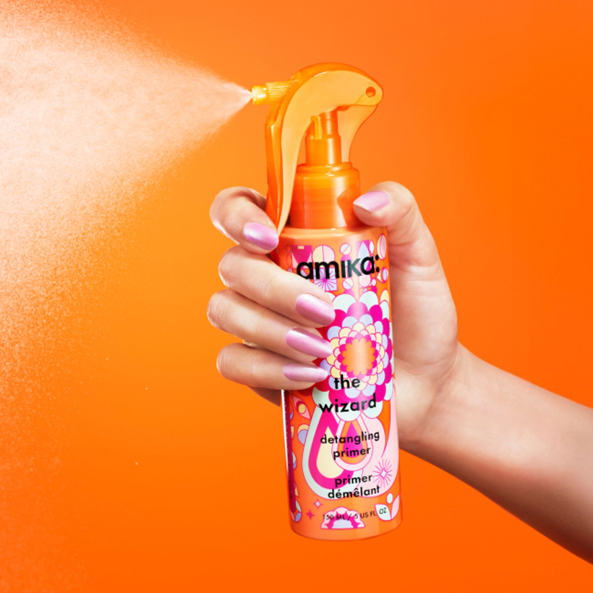 Image of a hand holding down the nozzle trigger on our NEW 11.8 oz jumbo wizard detangling spray