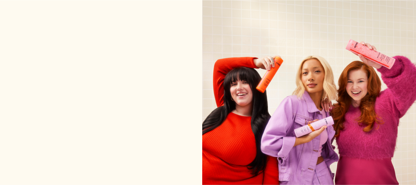 amika models holding shampoo and conditioner bottles in front of cream tile background