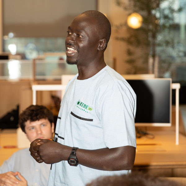 Image from amika's annual NYC climate week panel called Receipts of Real Impact, of Ojok from Okere City, Uganda who stood up and shared how amika and Forested’s work has directly shaped his community