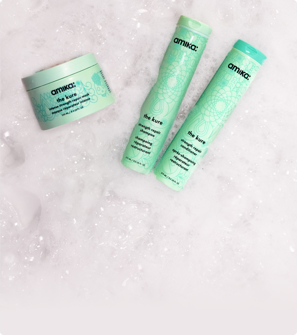 amika the kure shampoo, conditioner and intense mask sit amongst sudsy bubbles