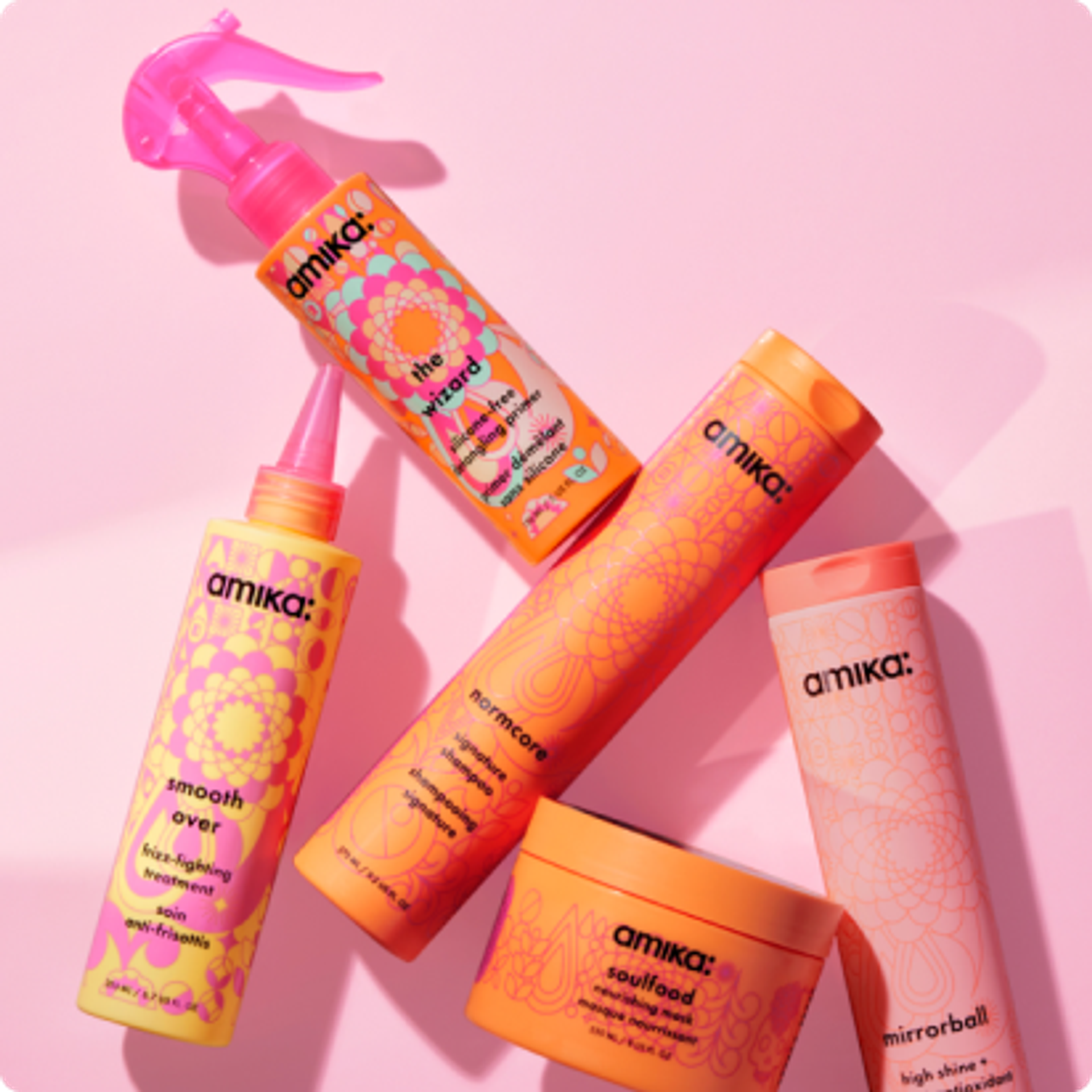 a collection of amika bestselling products on a light pink background