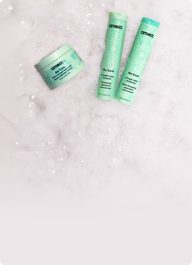 amika the kure shampoo, conditioner and intense mask sit amongst sudsy bubbles