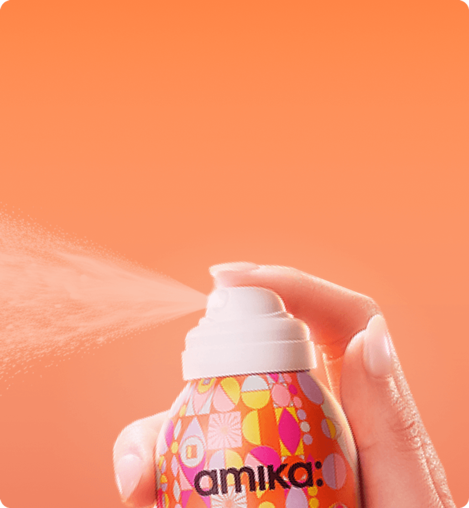a bottle of amika dry shampoo spraying against an orange background