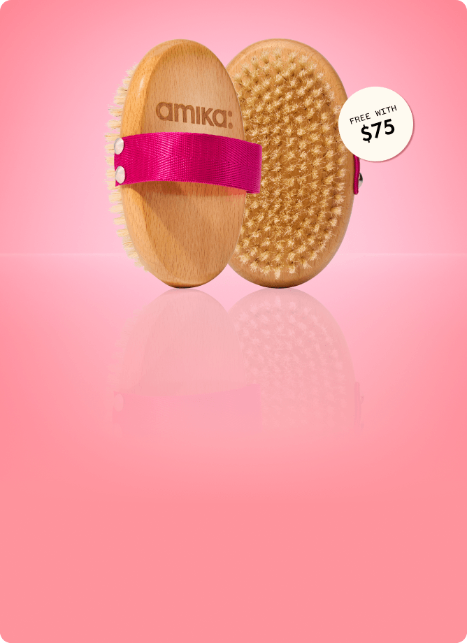 a dry body brush shown front and back stands against a pink background. a sticker reads: "free with $75" (orders)