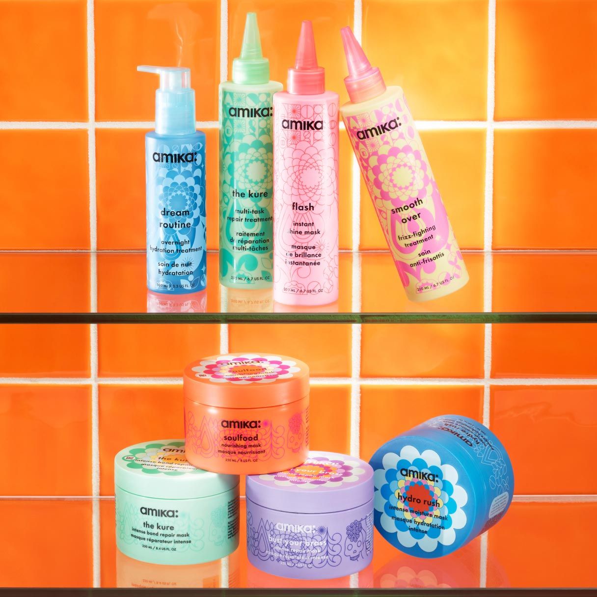 A collection of Amika hair care products displayed on glass shelves against an orange tile background.