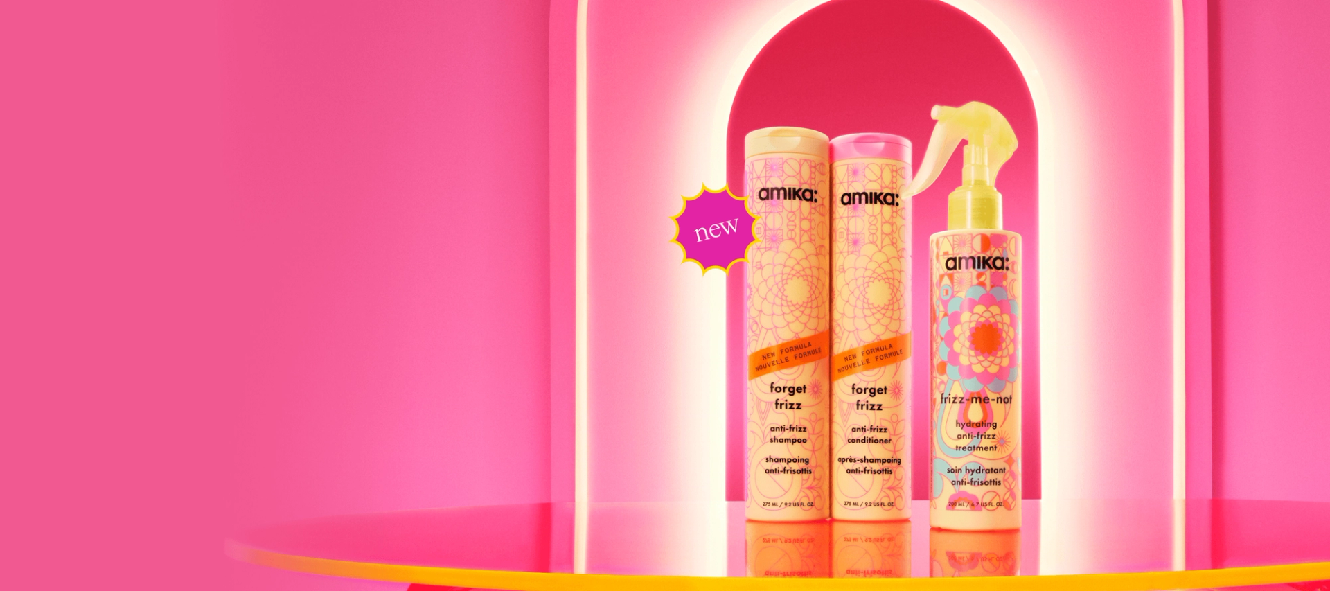Image of the NEW frizz collection against a pink salon background. Products featured include forget frizz shampoo and conditioner alongside the frizz-me-not treatment.