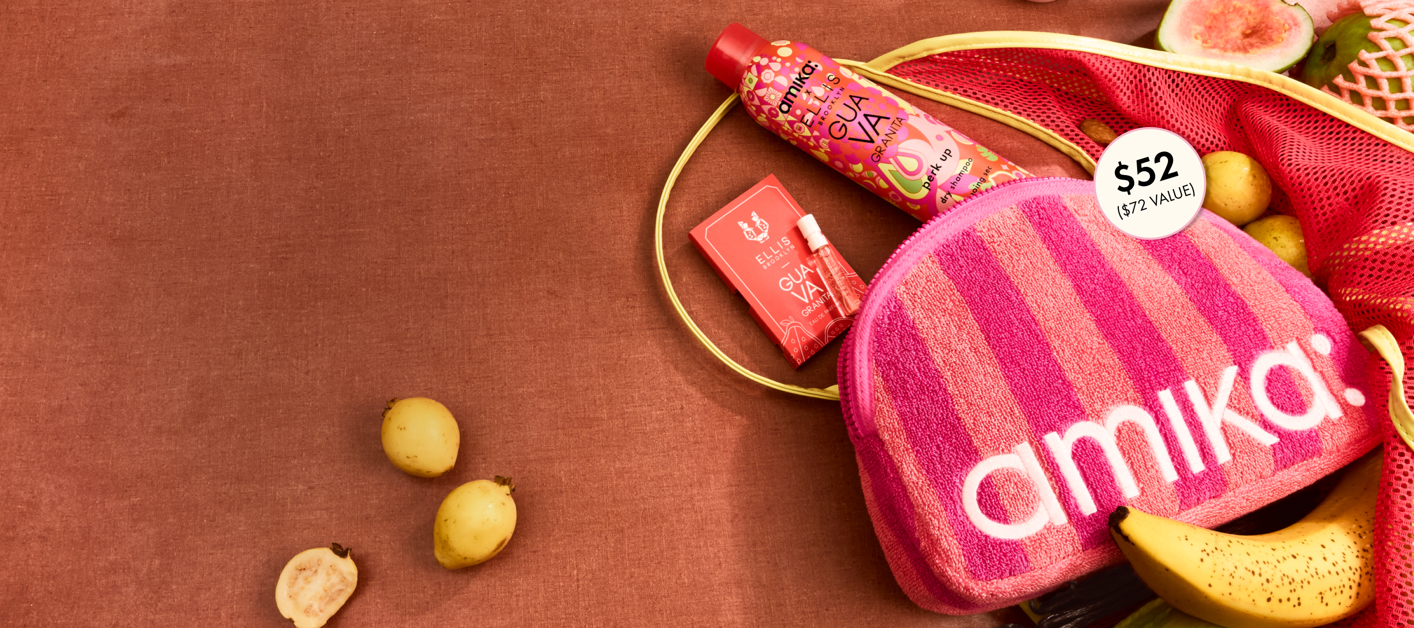 amika perk up GUAVA GRANITA, GUAVA GRANITA perfume sample, and pink striped logo terrycloth pouch lay amongst tropical fruits against a brown background