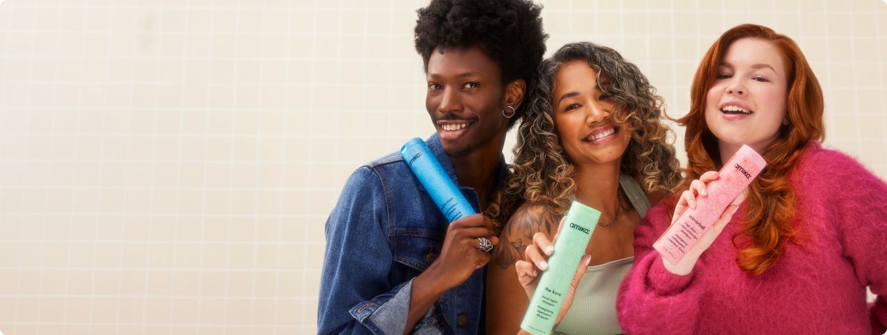 models posing with amika shampoo and conditioners on a white tile background