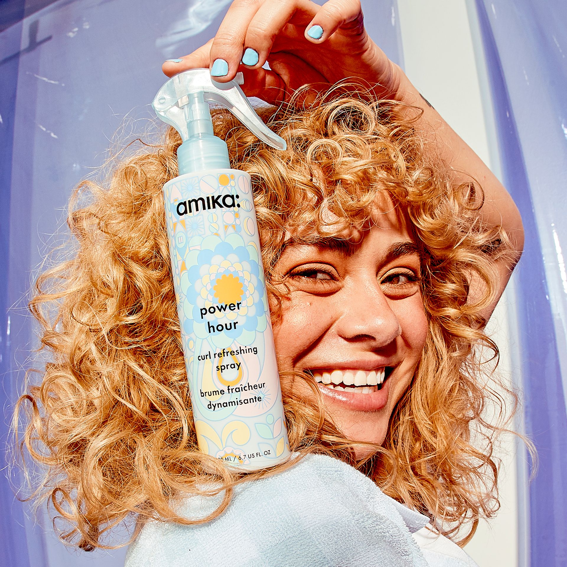model holding power hour curl refreshing spray next to their hair