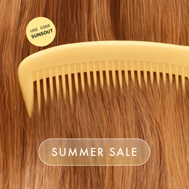 a yellow comb is moving through reddish wavy hair