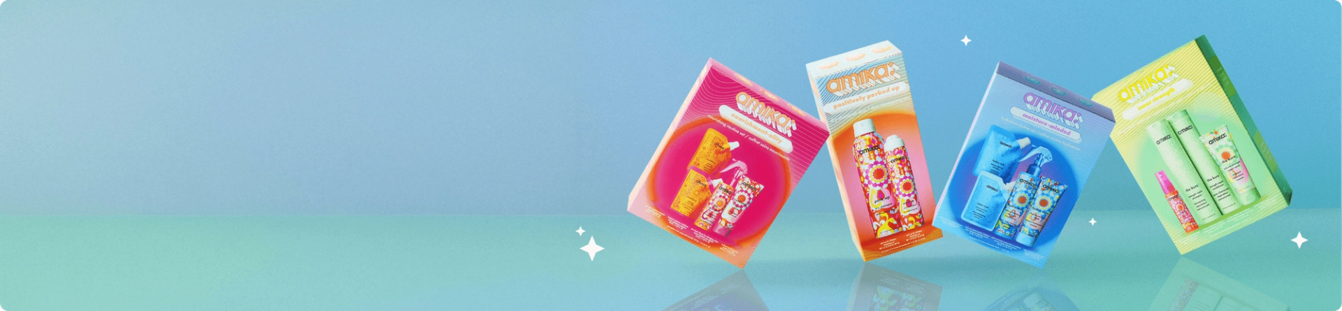amika holiday gift sets are arranged playfully against a blue gradient background