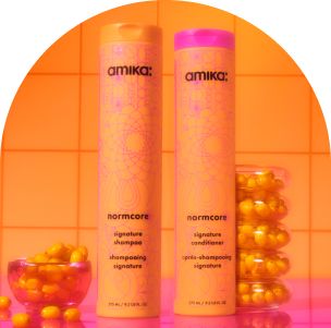 Image of normcore signature shampoo and conditioner against an orange tiled background.