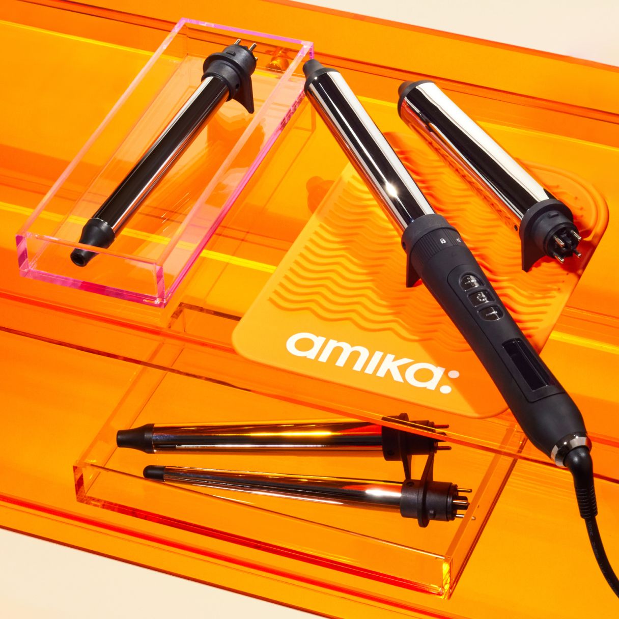 amika's chameleon curling iron on an orange table