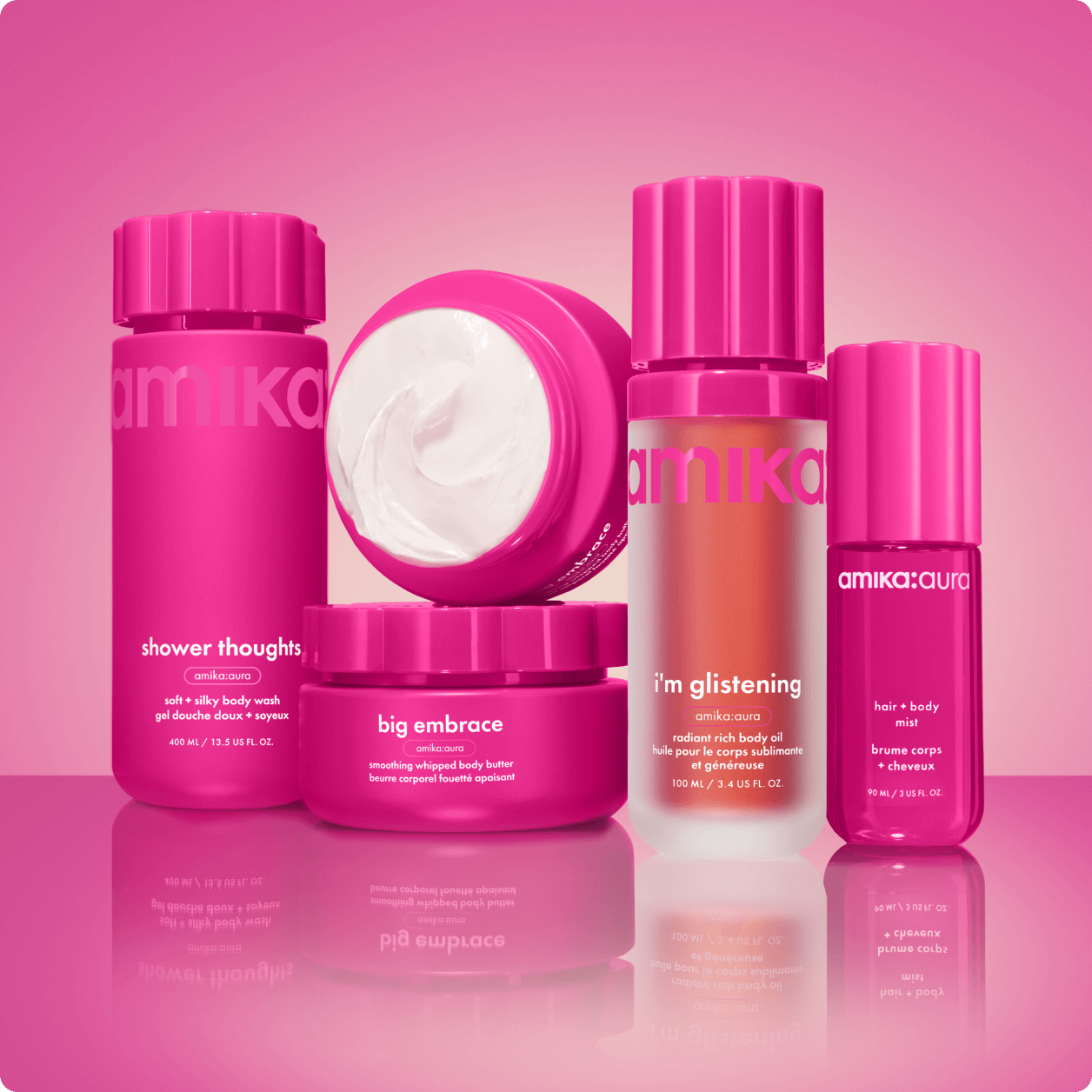 amika shower thoughts body wash, i'm glistening body oil, big embrace body butter, and amika:aura hair and body mist sit against a pink gradient background