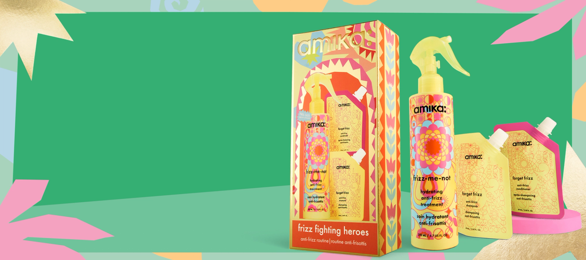 amika frizz-fighting heroes haircare gift set with a bottle of frizz-me-not treatment and small pouches of forget frizz shampoo and conditioner. they are set against a green background and a patterned pastel border